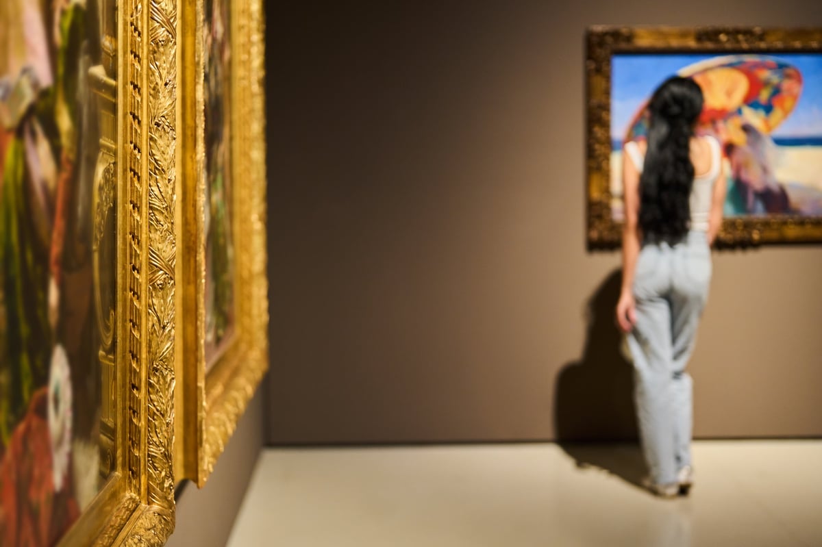 Women in museum looking at art gallery exhibition