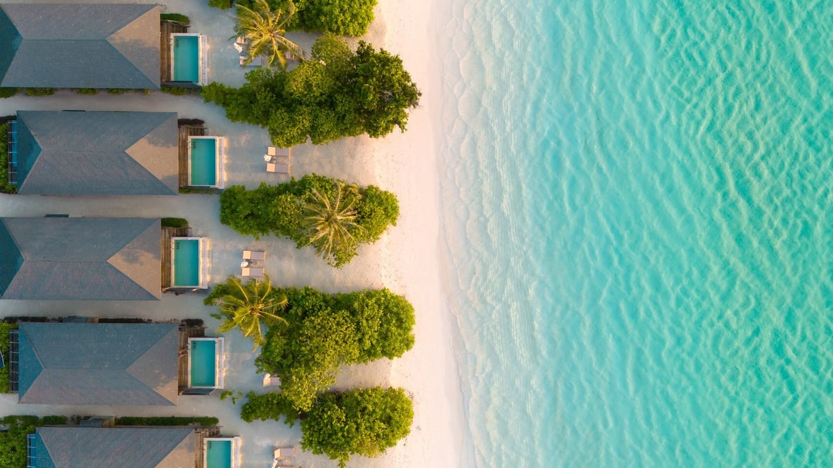 Scenic aerial shot of resort island in Maldives surrounded by blue sea