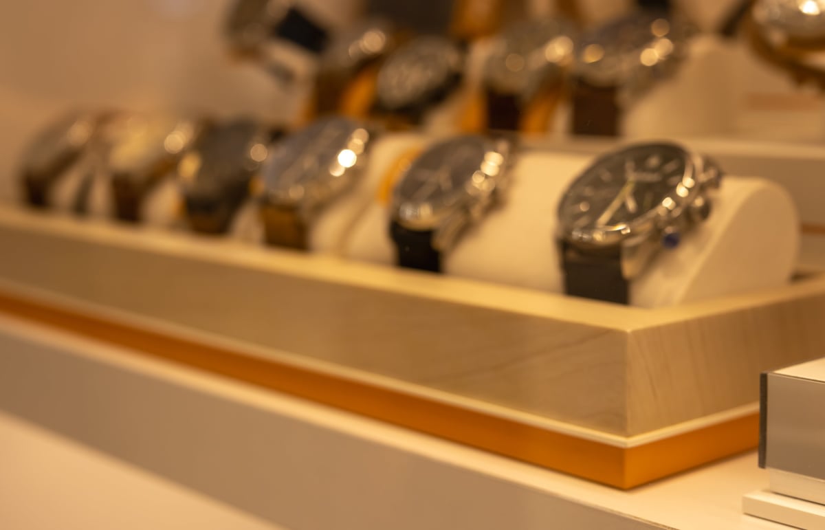 Close-up of luxury watch display case with elegant wristwatches on wooden stands