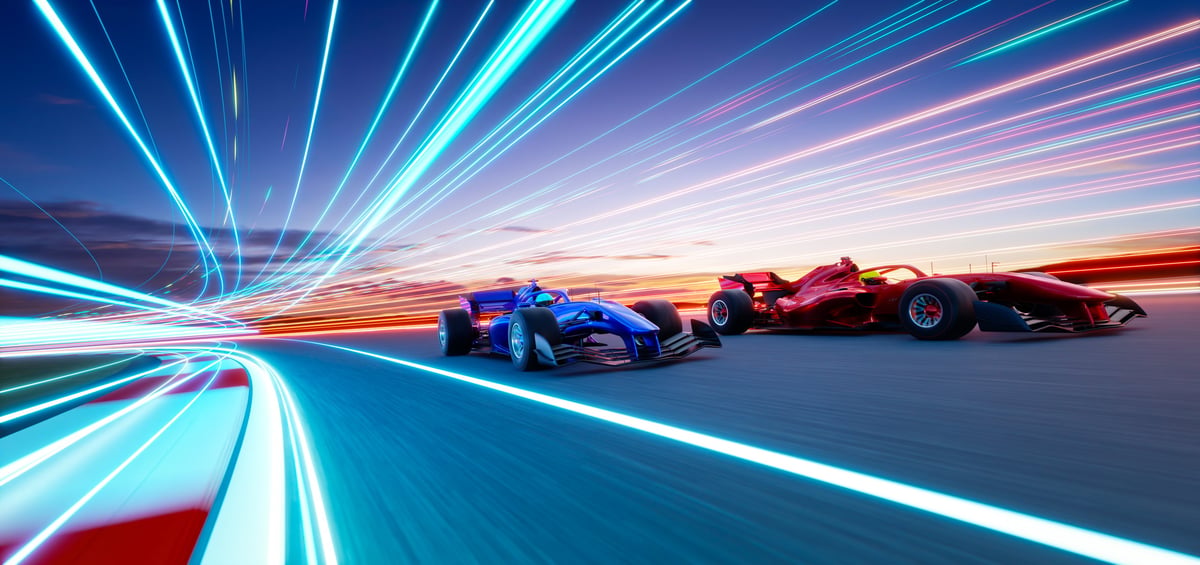 Red and blue racing cars competing on a futuristic track with light trails