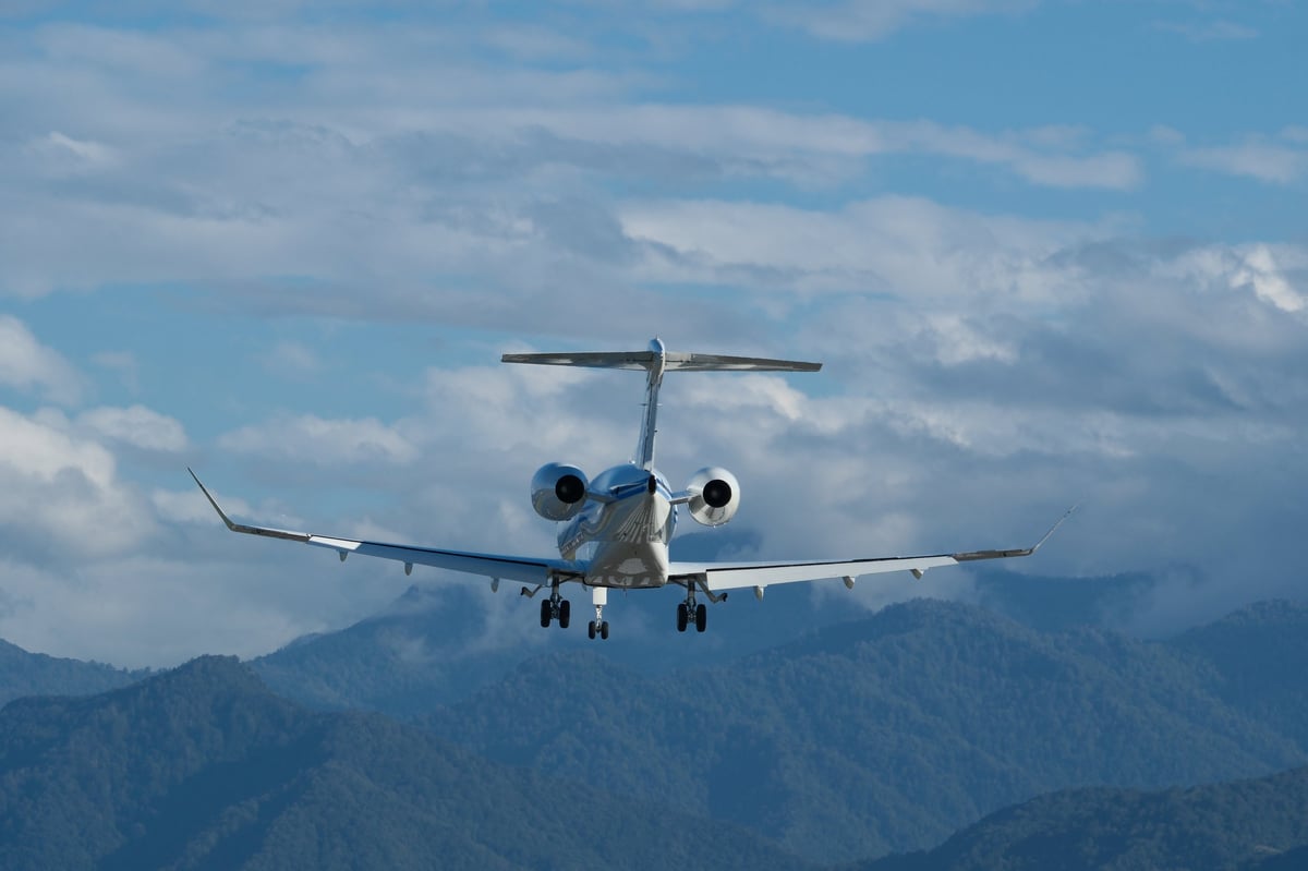 Landing of a private plane at Batumi Airport against a backdrop of mountains and a cloudy sky