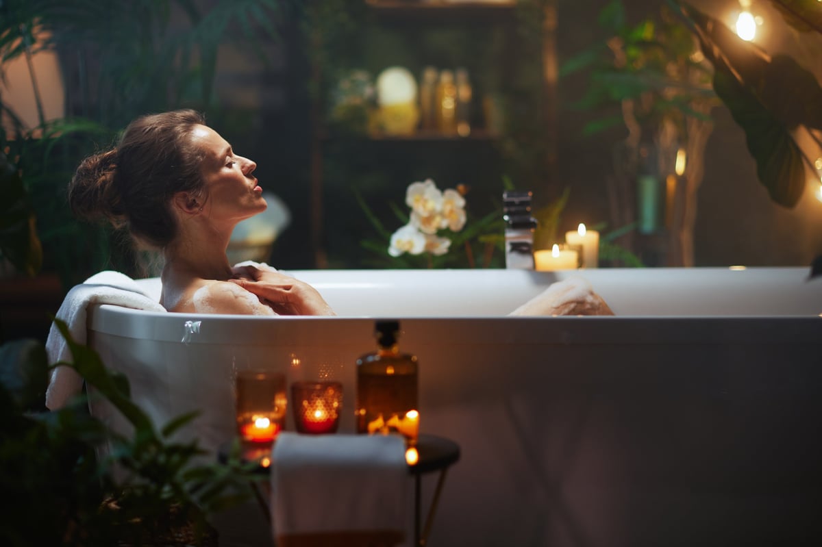 A woman finds serenity in a white bubble bath