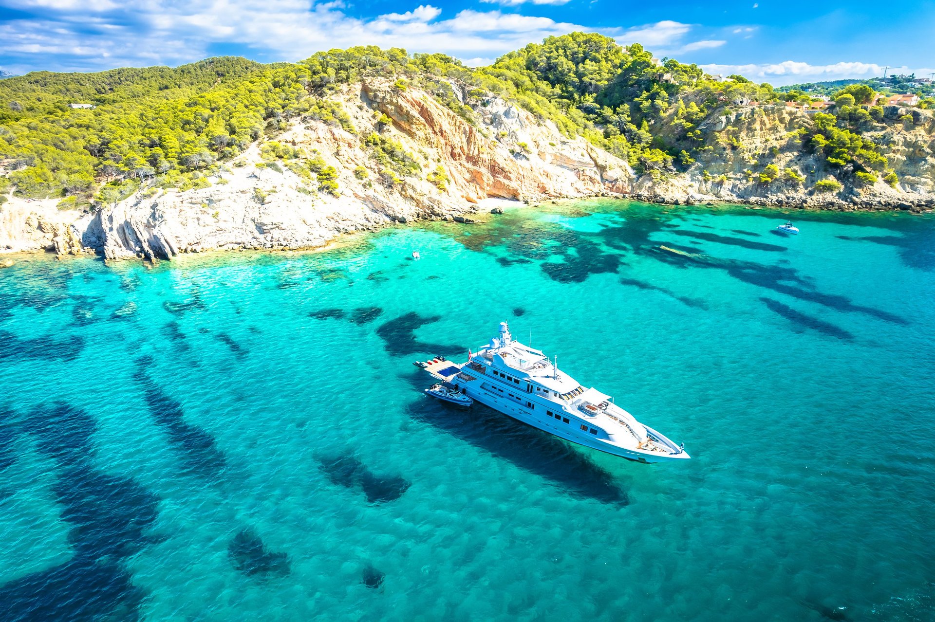 Luxury superyacht on turquoise Mediterranean sea coast aerial view Balearic islands Spain