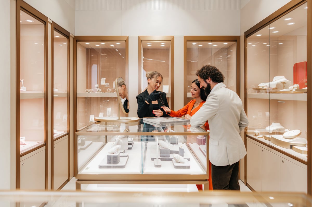 Sales assistant showing precious jewelry in a high-end luxury boutique