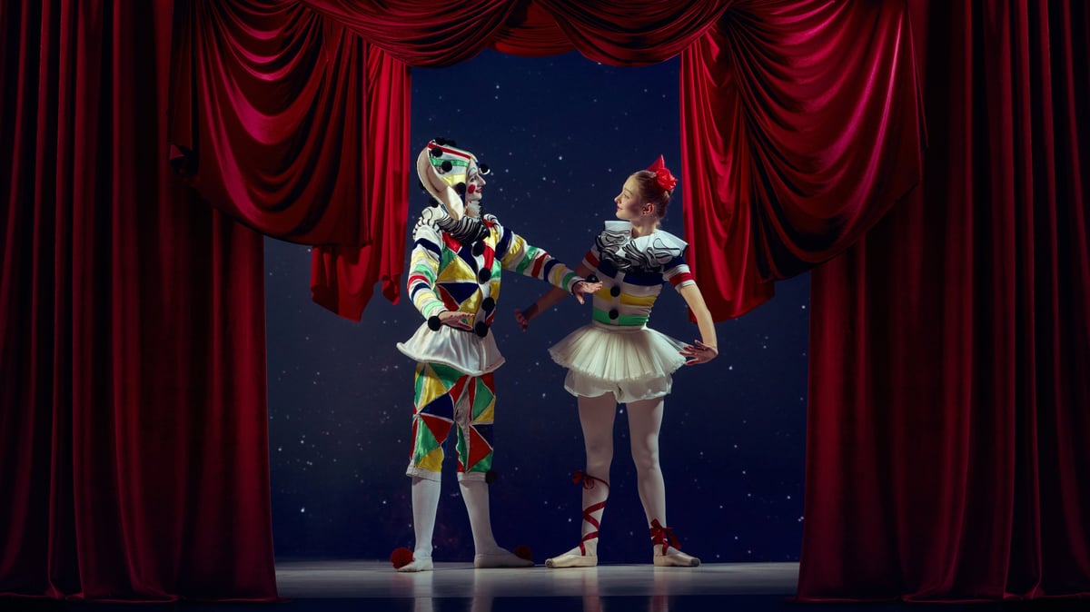 Life on stage. Mime and ballerina standing together on theater stage in colorful costumes.