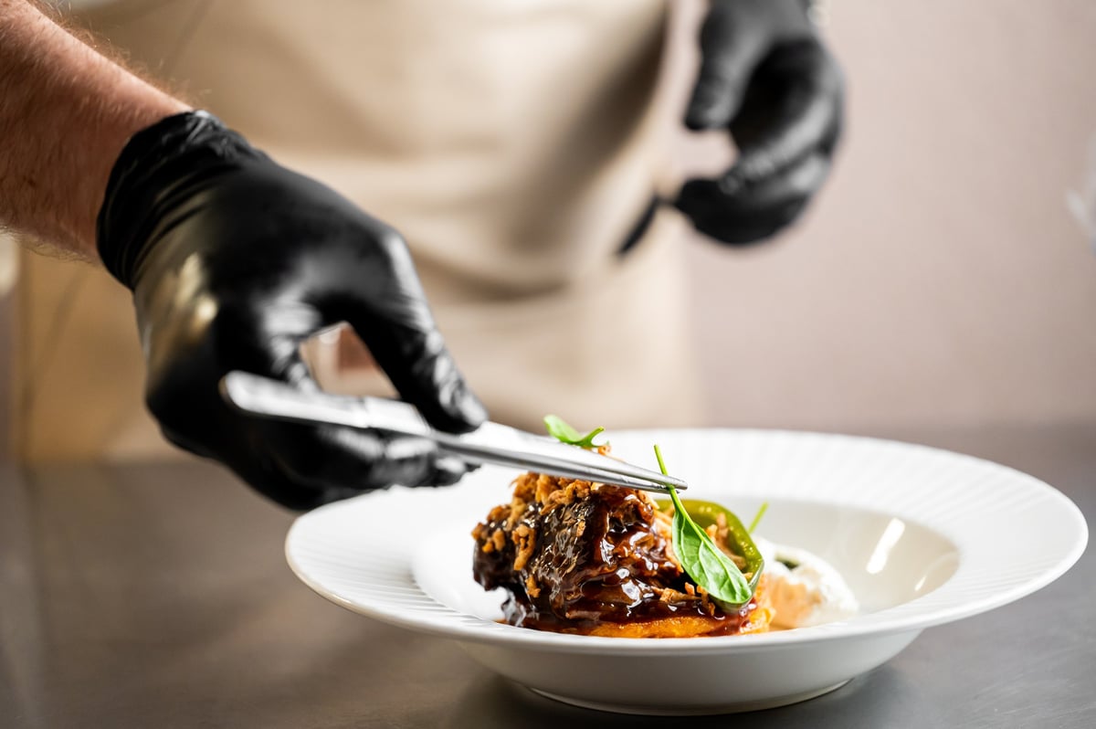 Chef placing garnish on gourmet dish