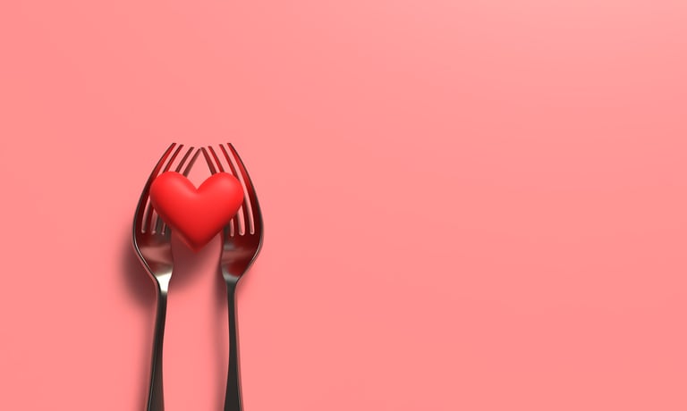 Heart shaped fork with food, romantic red pink color background