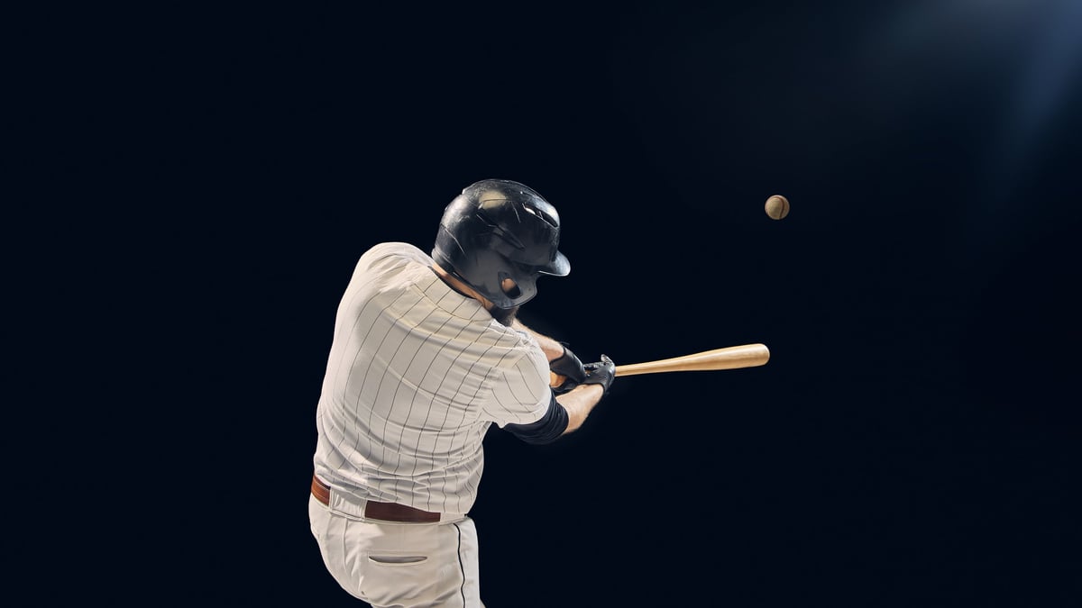 Baseball player hitting ball with bat during game action