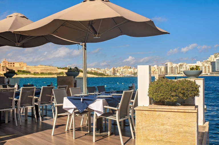 Elegant seaside restaurant terrace with tables under umbrellas