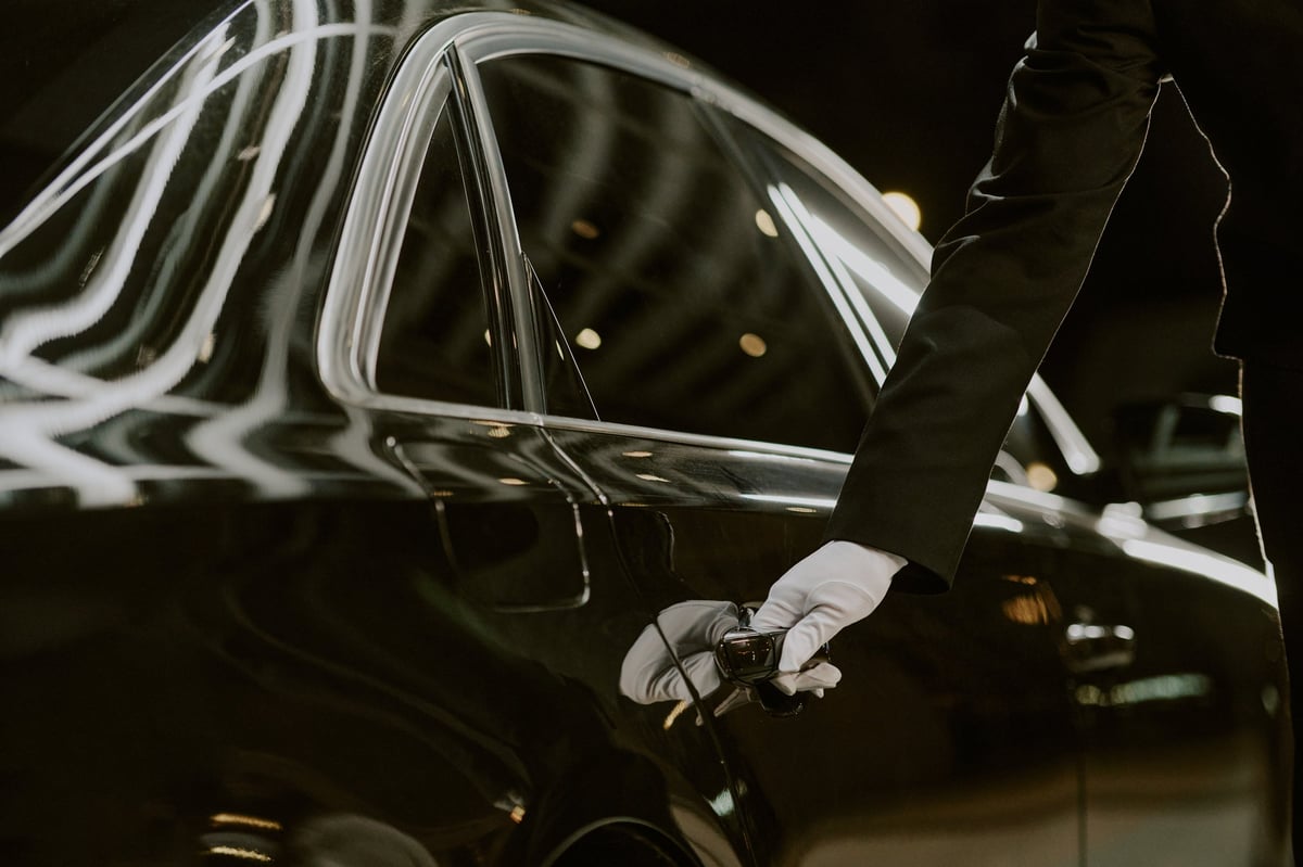 Chauffeur opening luxury car door