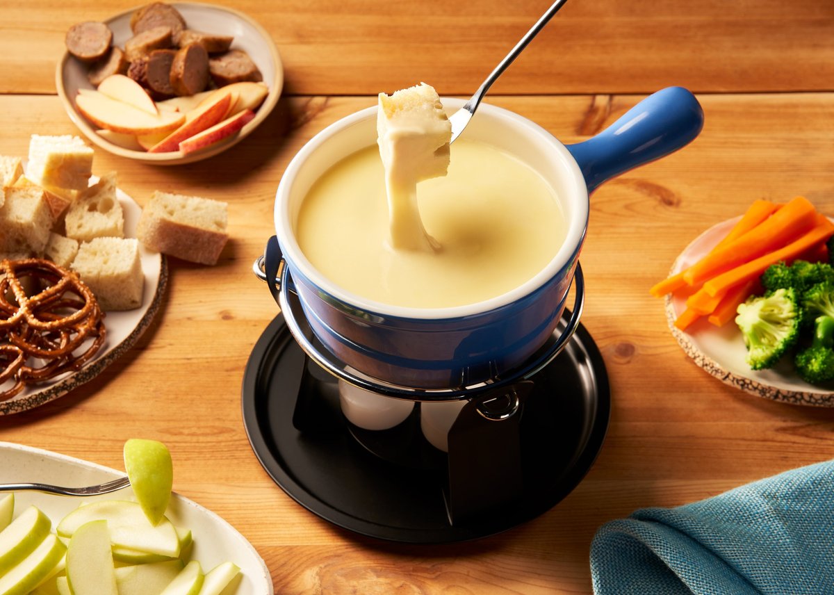 Swiss cheese fondue surrounded by dipping items