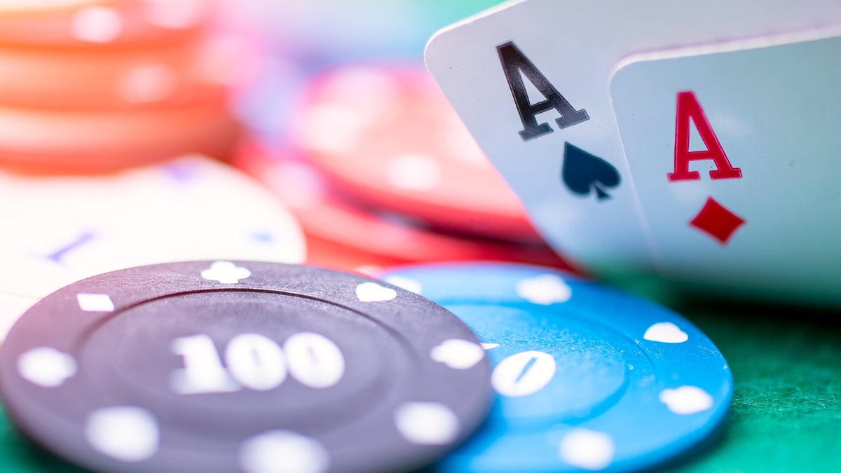 Two aces and poker chips on the red table with substantial wager