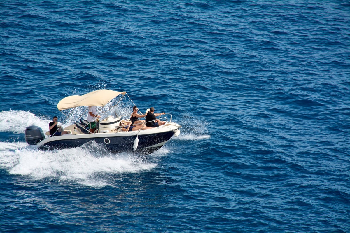 Dubrovnik. Croatia - A group of friends has fun on a speeding motorboat in the blue sea.