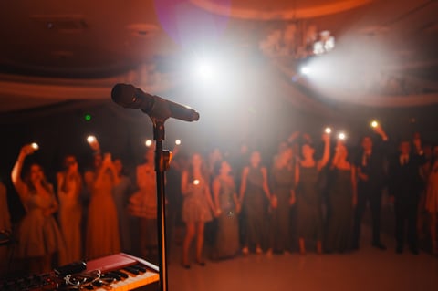 Guests at a lively party gather to enjoy music performed on stage