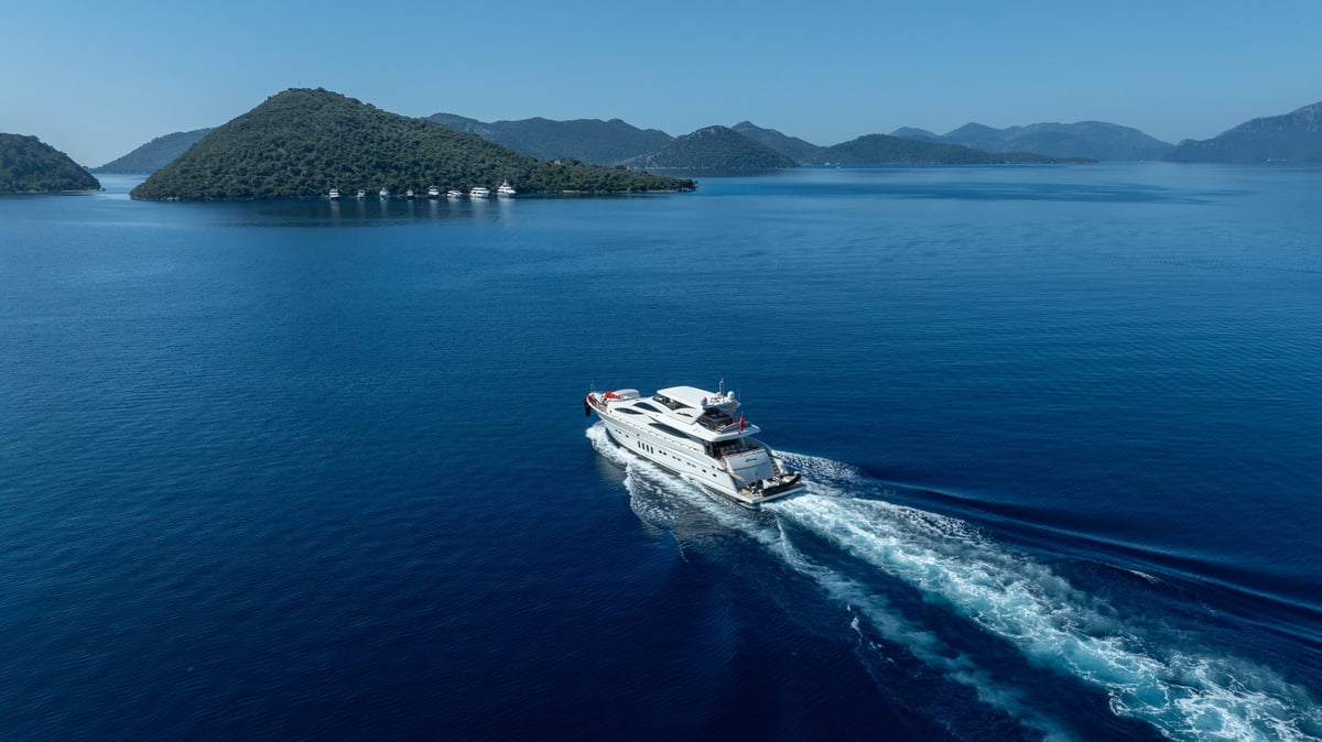A premium white yacht cruising smoothly across deep blue waters, highlighting elegance and modern marine craftsmanship
