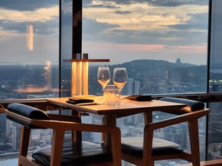 Elegant restaurant table set with wine glasses and soft ambient lighting near a large window