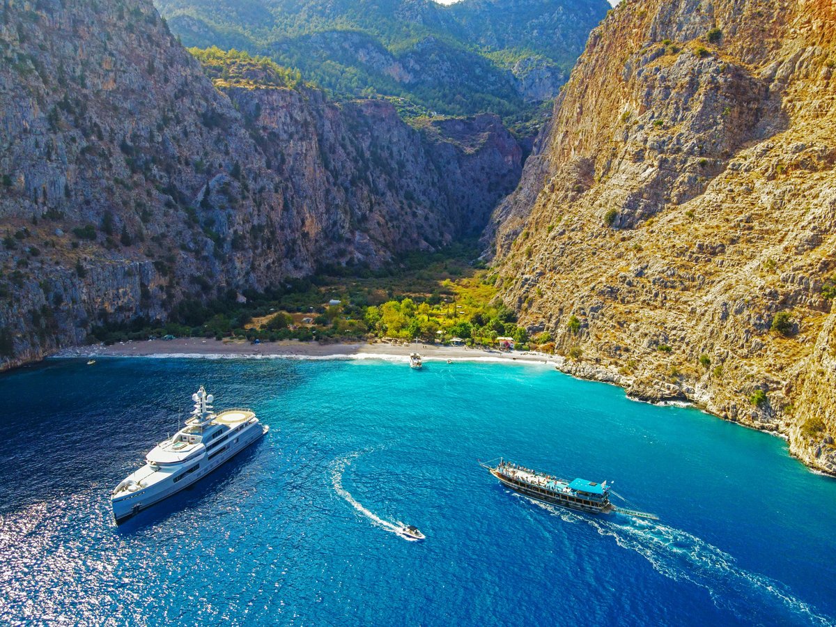 Aerial view of a protected natural canyon and beach with crystal clear turquoise waters on the Mediterranean coast
