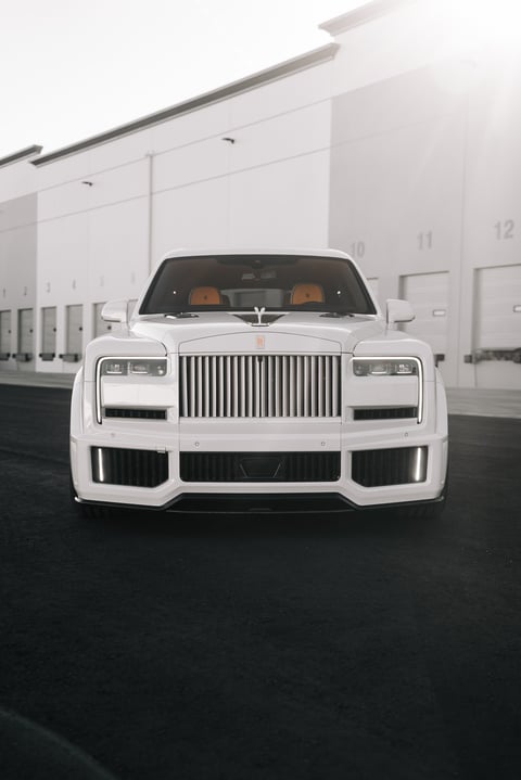 White Rolls Royce Cullinan luxury car parked showing the front