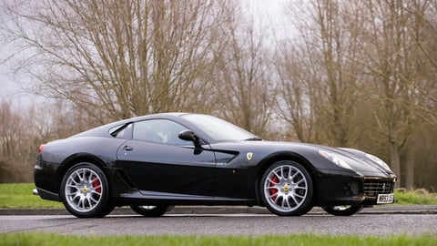2008 black Ferrari 599 classic car driving on a British road