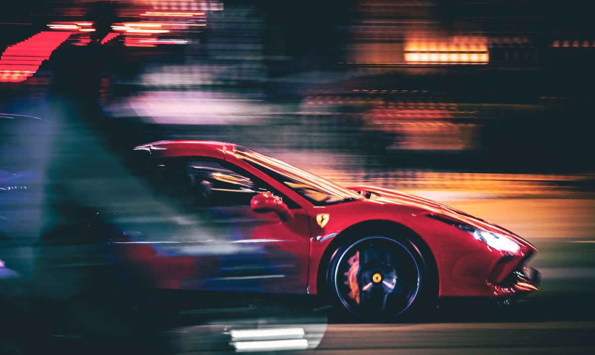 Red Ferrari supercar driving at night with motion blur effect