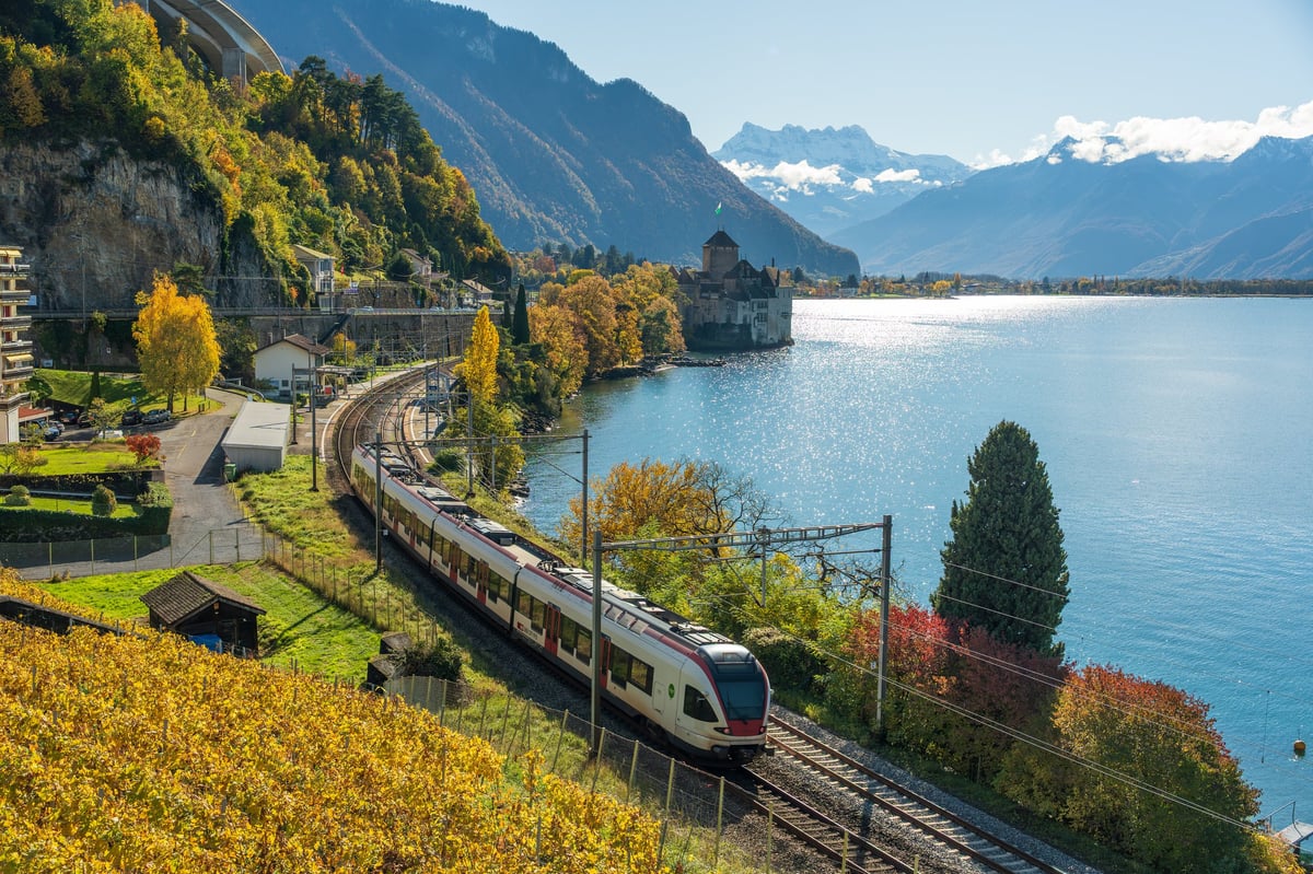 Train passing castle on Lake Geneva shore