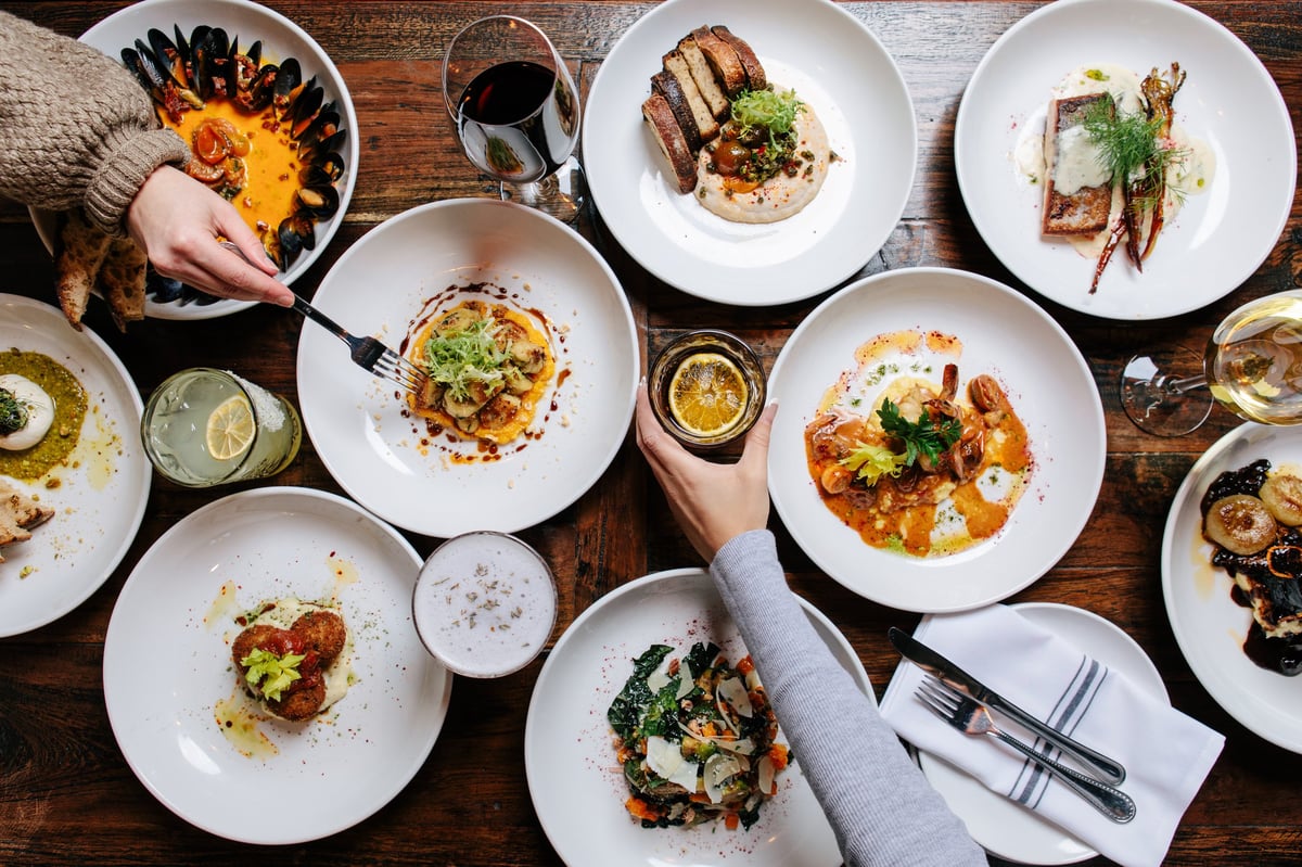 A birds-eye view showcases a bountiful spread of delicious dishes and beverages on a rustic wooden table