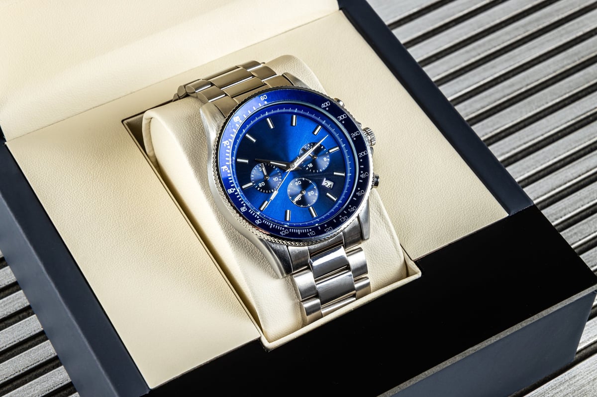 Stylish men's wrist watch with metallic strap and blue face in presentation box