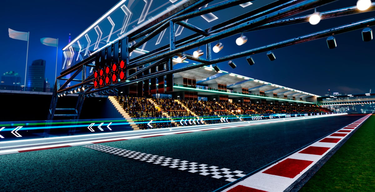 Racetrack starting grid with lights and grandstands at night, Formula 1 atmosphere