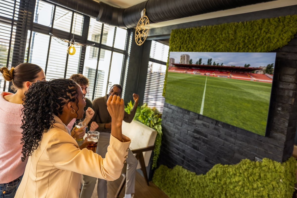 Group of friends watching a match on TV cheering