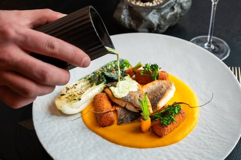 Premium fish dish with artistic garnish served in an upscale dining setting