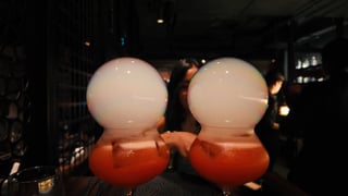 Cocktail on a rooftop bar overlooking city skyline at night