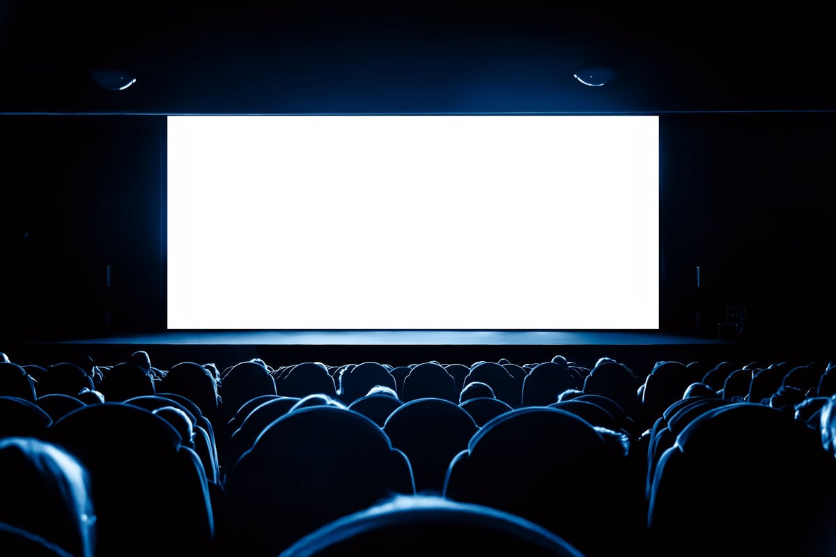 People in a cinema watching a movie on blank white screen