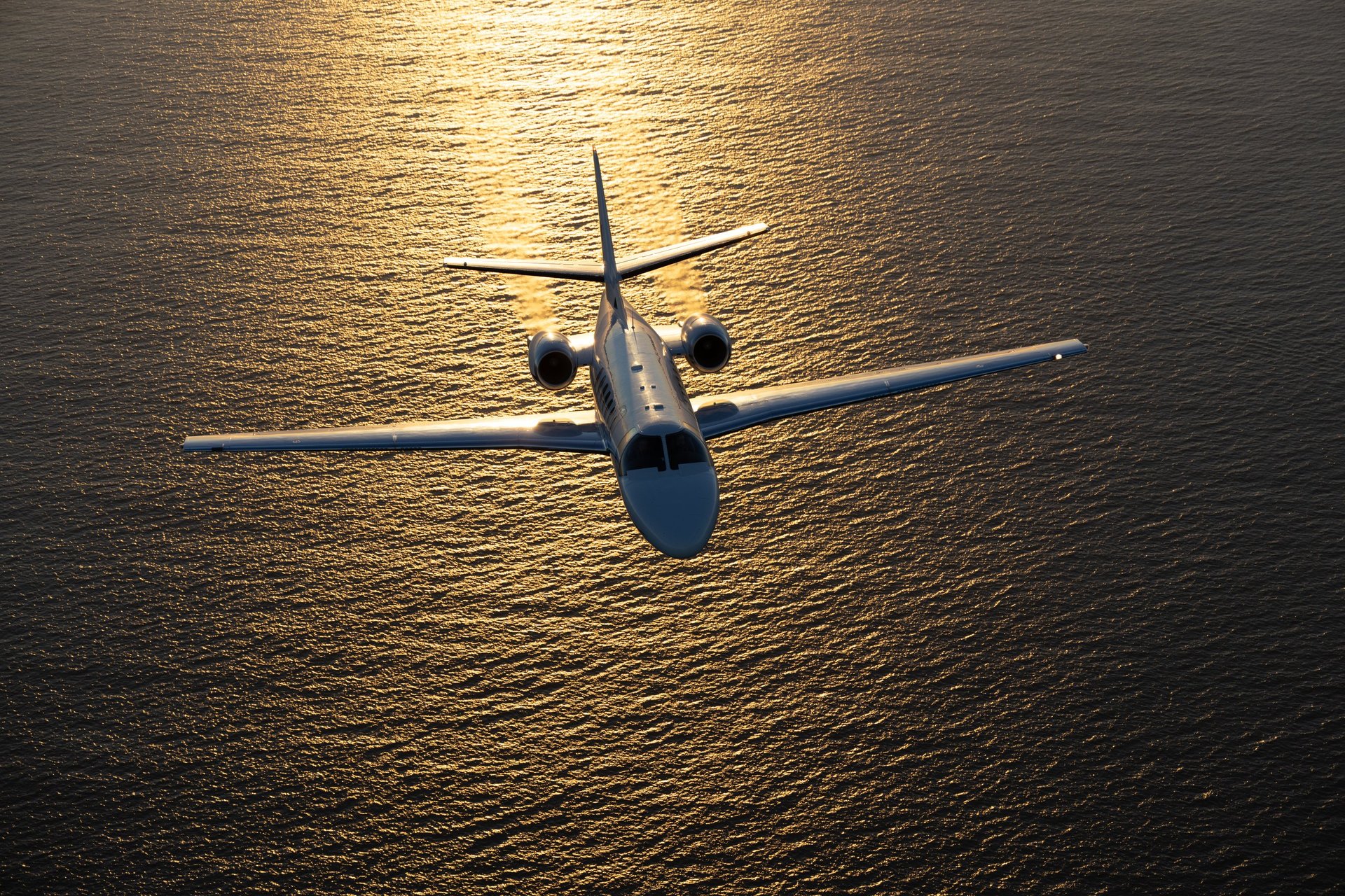 Business jet in beautiful sunset light over the Pacific Ocean