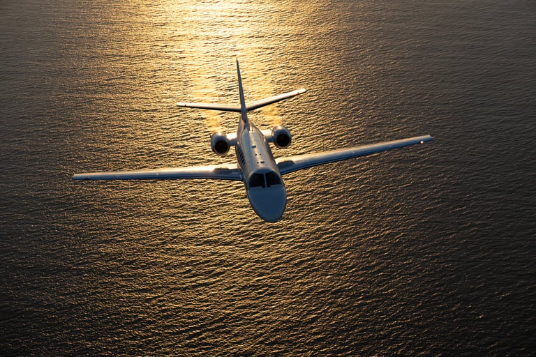 Business jet at sunset over Pacific Ocean