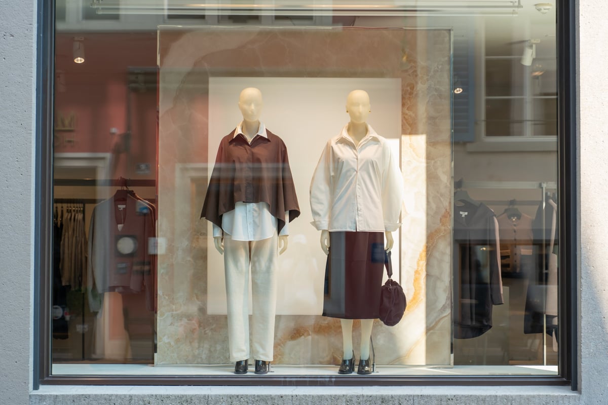 Storefront window featuring mannequins dressed in modern womenswear luxury fashion