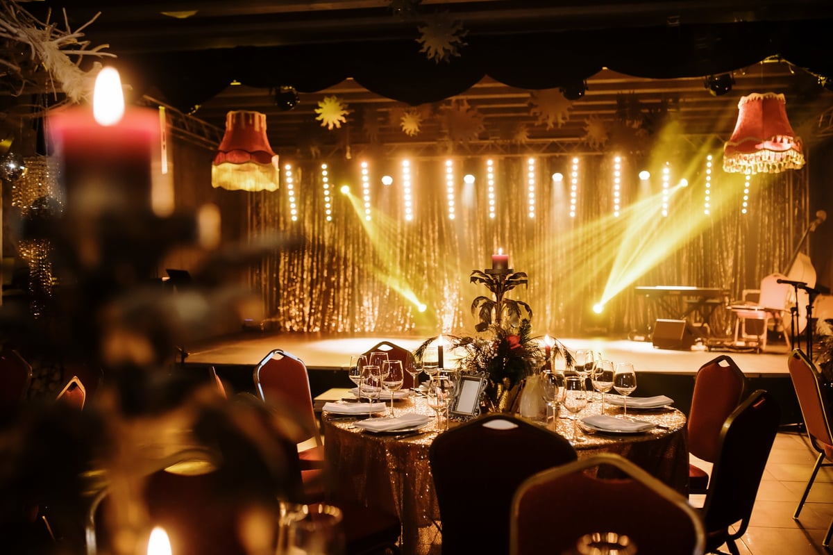 A luxurious festive table with a glowing candle centerpiece, surrounded by elegant decorations, golden bokeh lights, and a cozy atmosphere, perfect for a glamorous holiday celebration