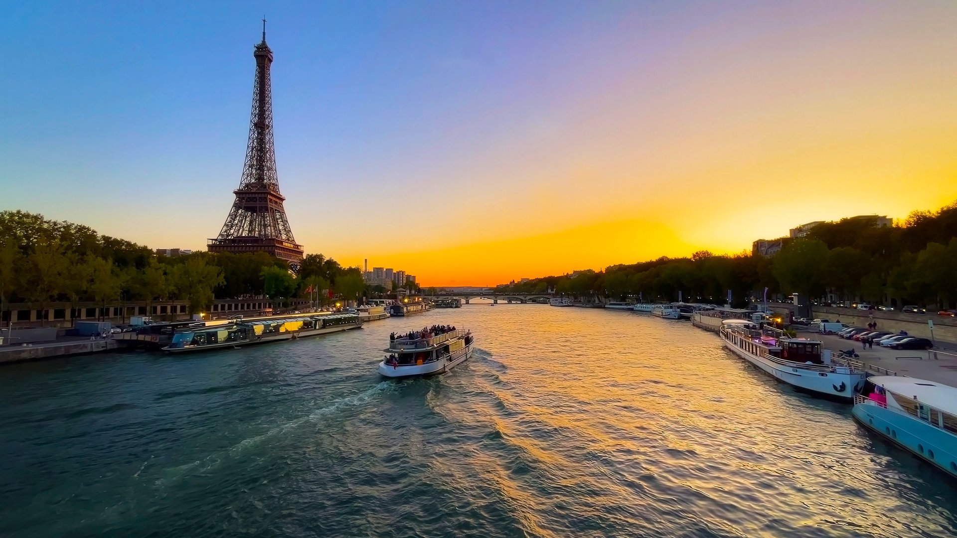 Eiffel Tower and boats on the Seine River at sunset