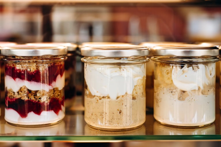 Portion desserts served in jars displayed on a pastry shop or cafe showcase