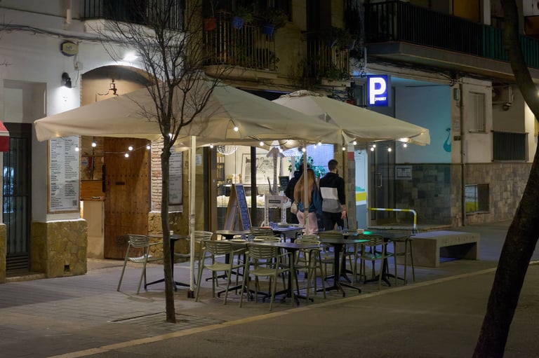 Night view of a quiet mediterranean cafe patio with string lights