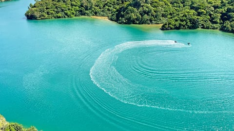 Emerald green sea with jet ski wakes