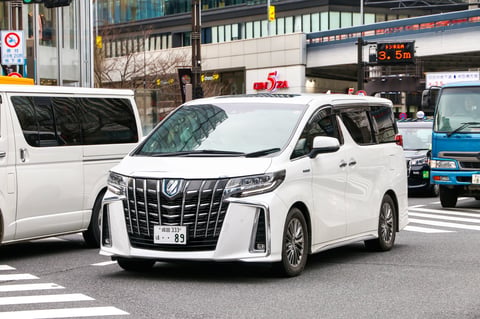 White luxury van Toyota Alphard at the city street in Tokyo