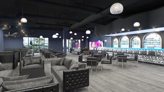 Contemporary lounge interior featuring plush gray seating and a well-lit bar area