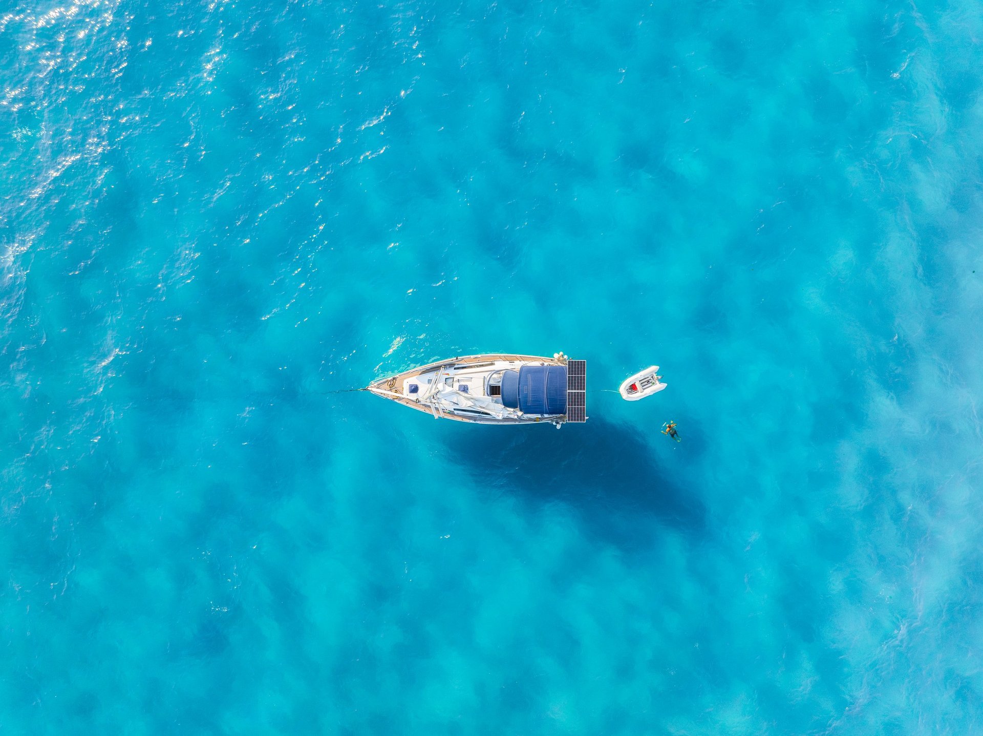Aerial view of a luxury yacht floating on turquoise ocean water
