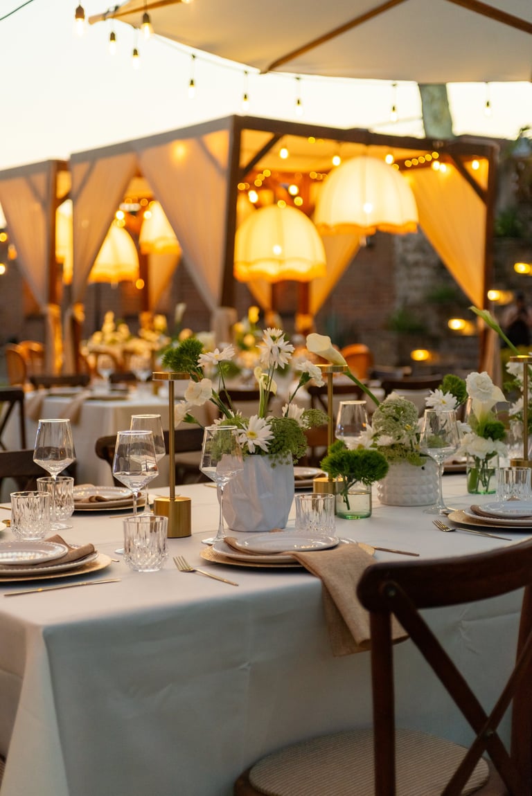 Elegant Outdoor Dinner Event Table Setting with Floral Centerpiece and Warm Lighting Ambiance