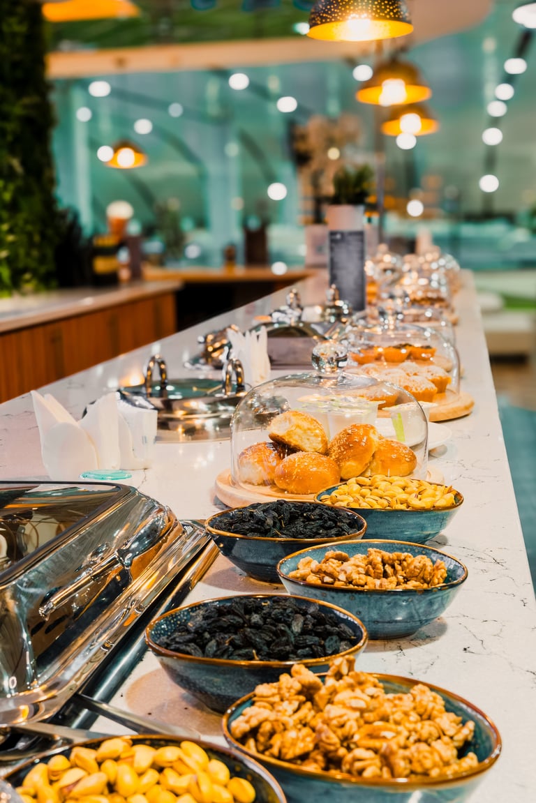 Premium airport lounge with assorted snacks, nuts, olives and fresh pastries on serving counter