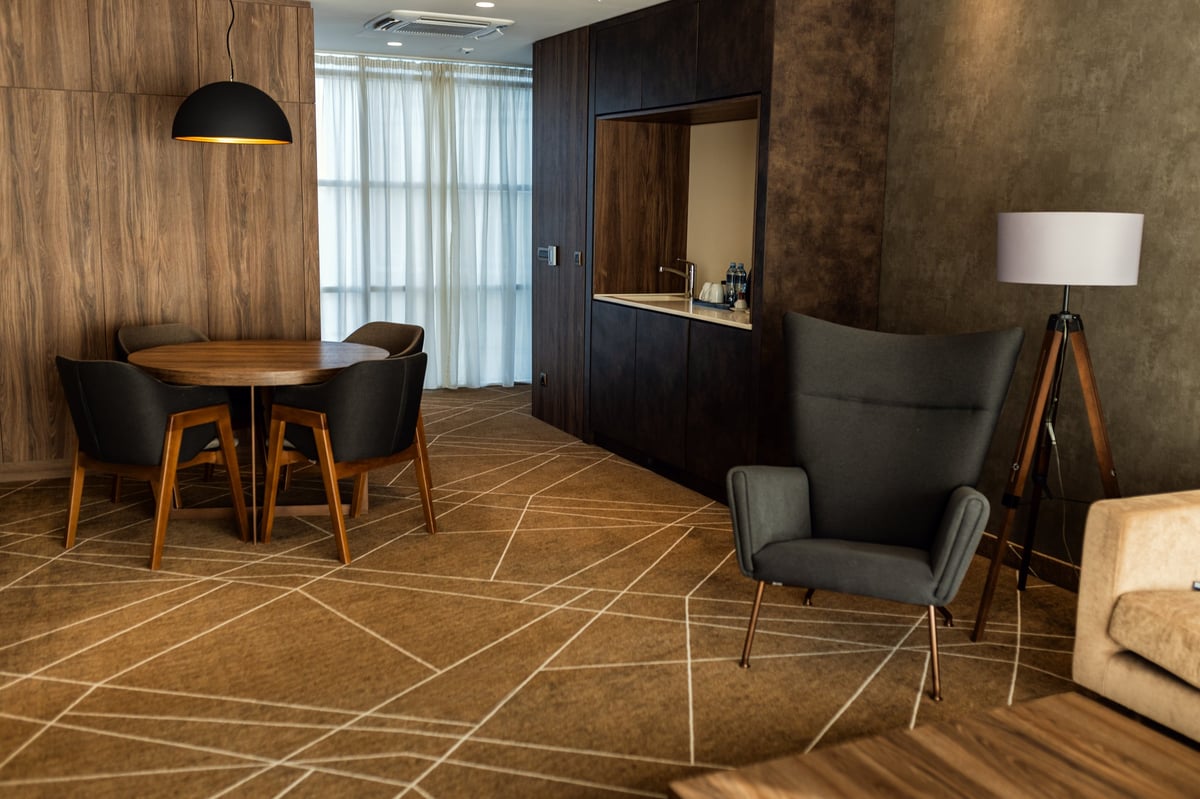 Modern luxury hotel room interior with dining table and armchair