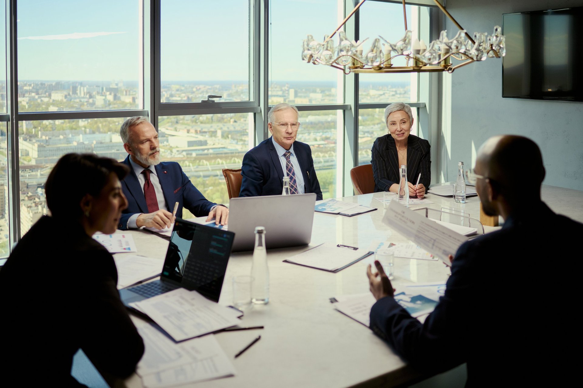 Executive business meeting in luxury corporate boardroom with skyline view, representing elite corporate concierge services