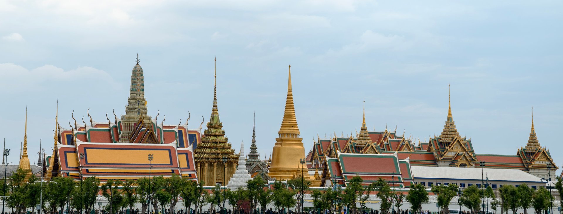 Panoramic view of the ornate golden stupas and traditional Thai architecture at the Grand Palace and Wat Phra Kaew temple