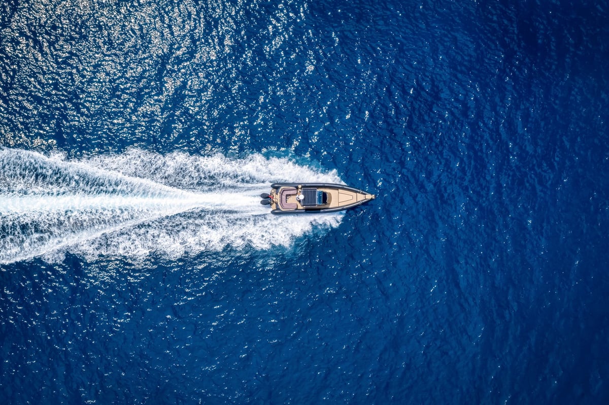 Modern luxury RIB twin outboard motorboat crossing blue ocean at high speed
