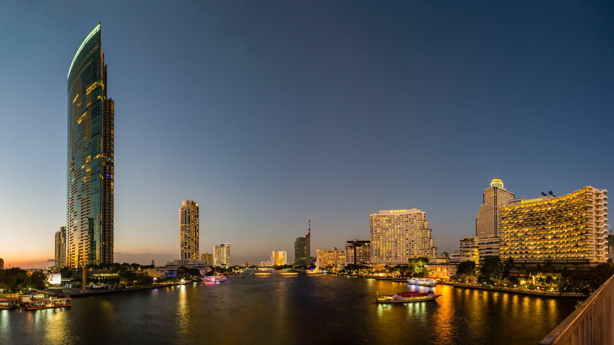 Panorama view of Chao Phraya River and various luxury hotels and condominiums along the Chao Phraya waterfront at dusk
